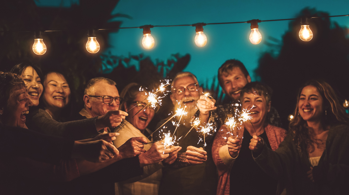 Group of adults smiling and lighting sparklers