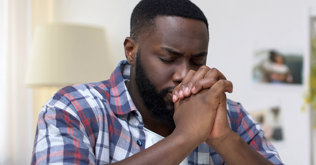 Close up of a man with hands folded in prayer