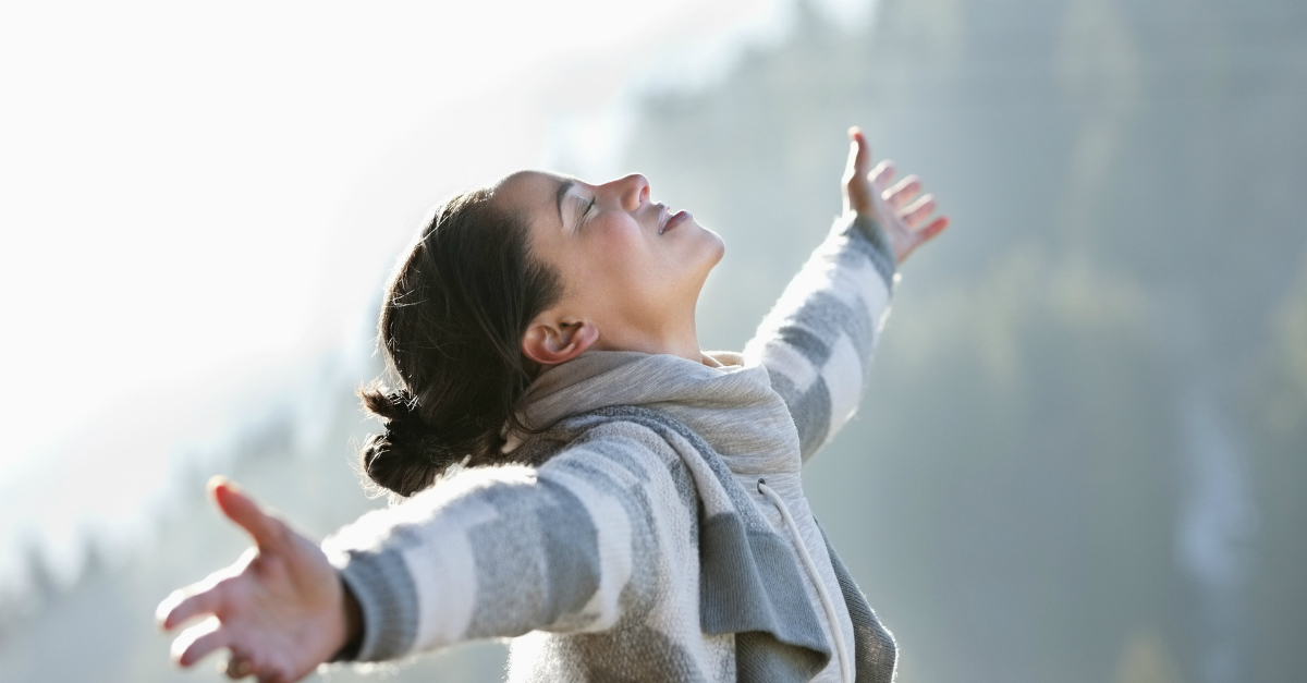 woman with arms out wide in praise