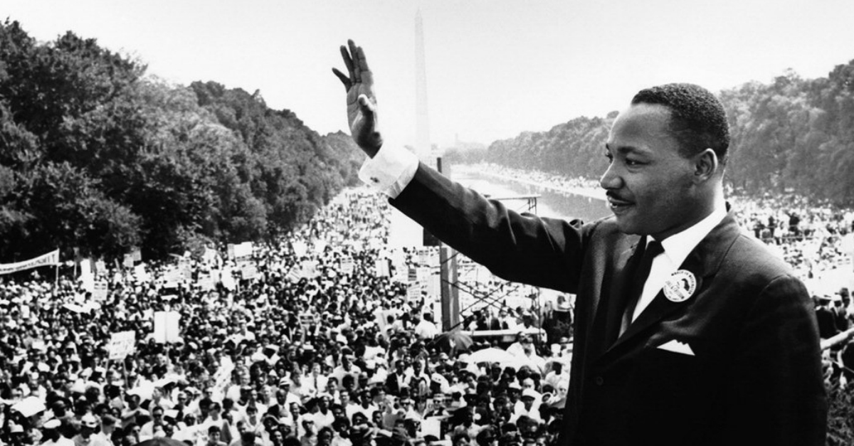 Black and white photo of Martin Luther King Jr. waving to a crowd.