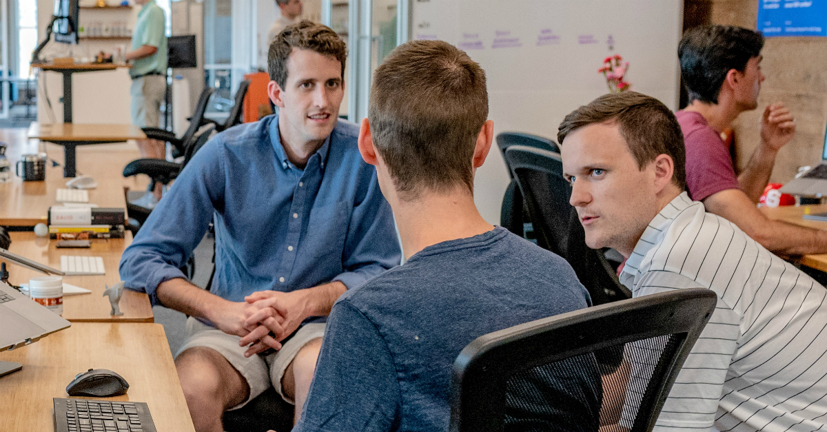 three men having planning conversation at work