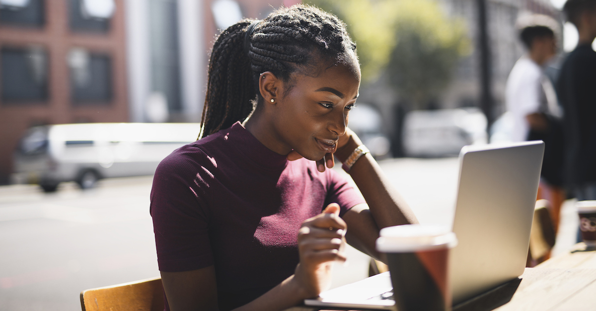 Young woman sitting outside on her computer