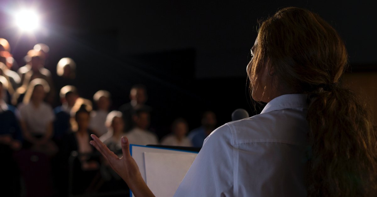 Woman giving a speech before a crowd