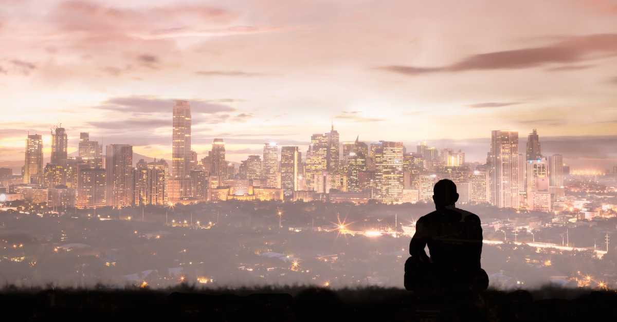 Man sitting alone looking out at a city