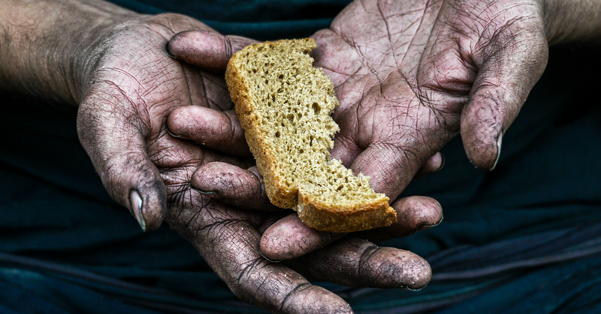 Dirty hands holding a small piece of bread