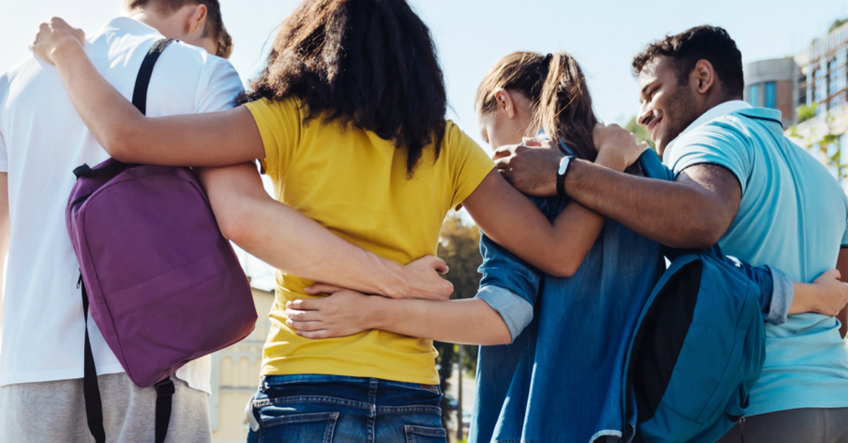 Group of young people with arms around each other's shoulders