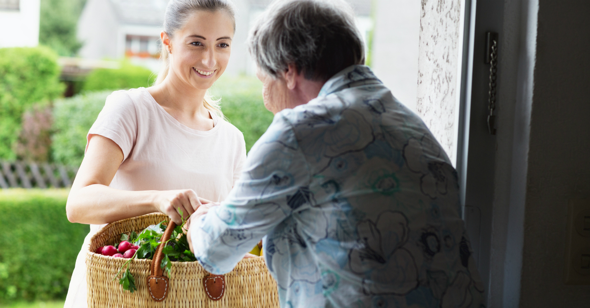 woman bringing groceries to elderly woman thoughts and prayers