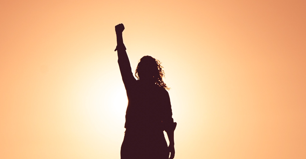 Silhouette of a woman with fist raised in victory