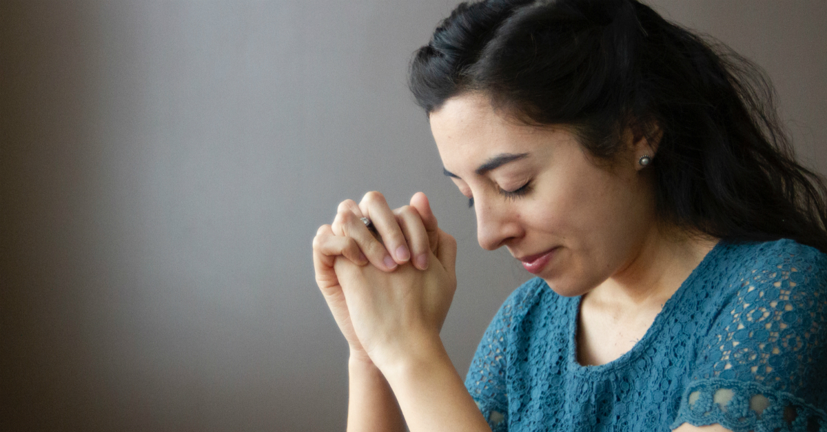 woman with eyes closed, hands folded in prayer, psalms for comfort