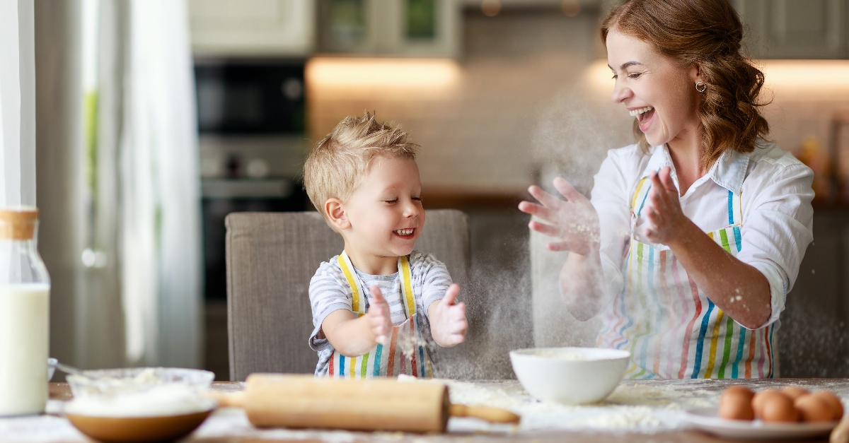 Mom and young son playing with flour while baking