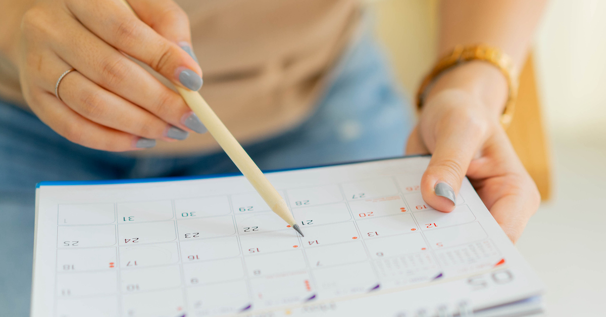 Woman planning out her week on a calendar