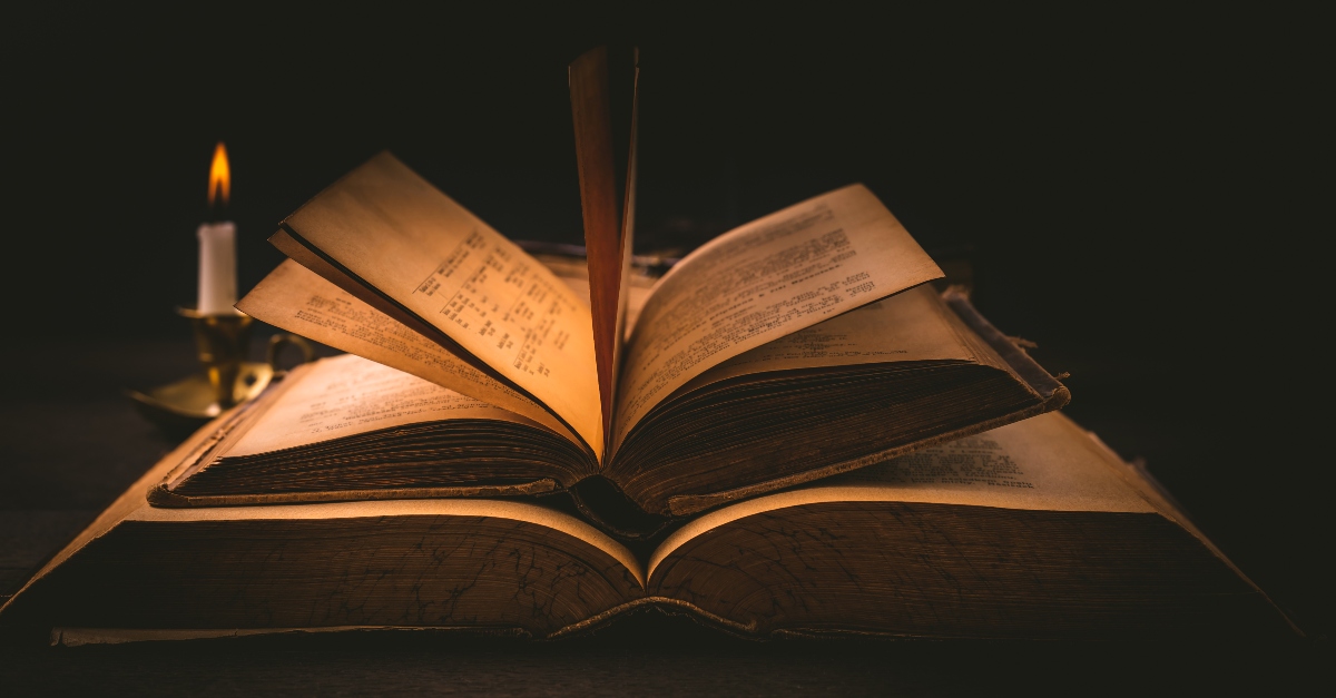 Two ancient books in candlelight