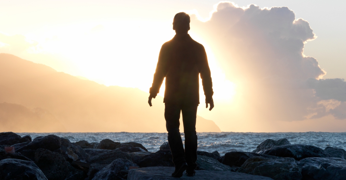 Silhouette of a man walking on the beach