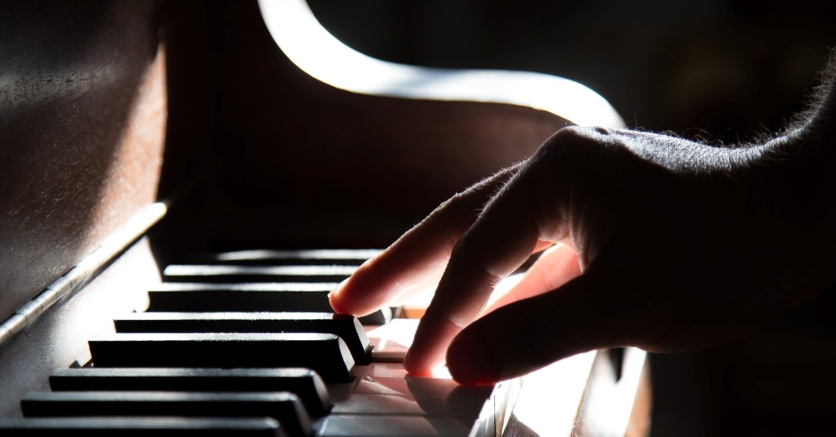 closeup mans hand playing piano