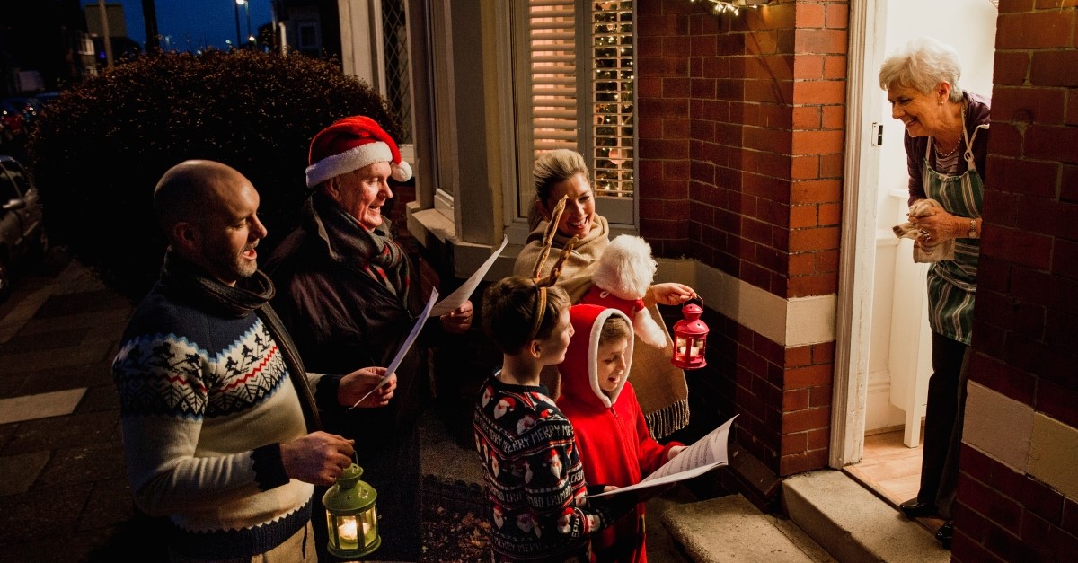 family caroling while happy older woman watches, christmas carol