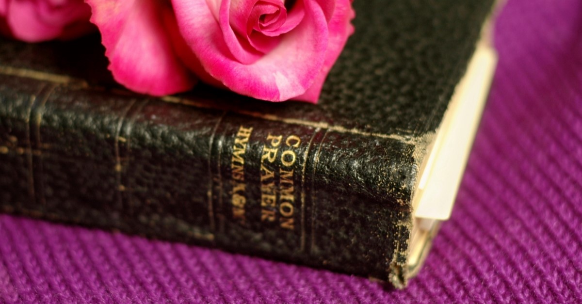 Book of common prayer with pink rose on top of it, prayers of the saints