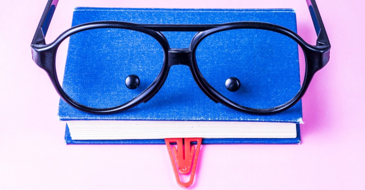 Book with glasses paperclip and buttons to look like face, comedy novels