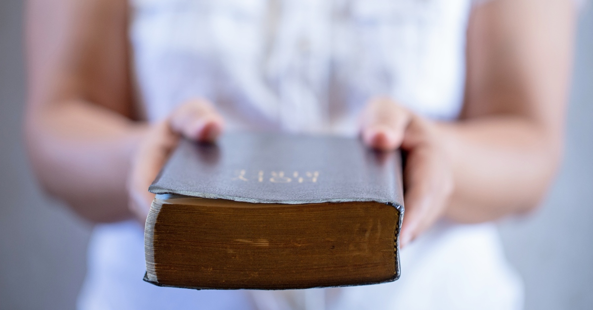 Woman handing a Bible