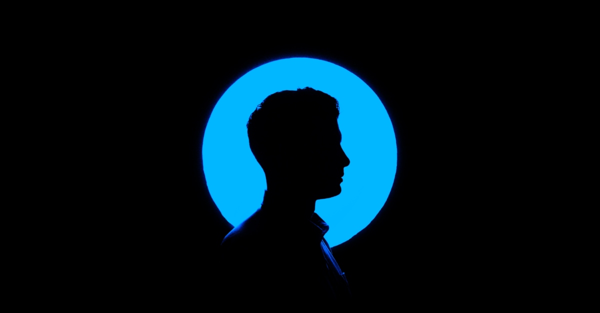 Side-view silhouette of a man's head with a blue circle around him