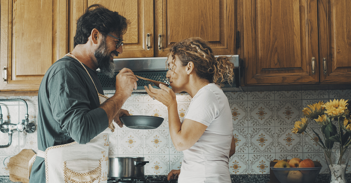 Cute happy married couple in kitchen cooking