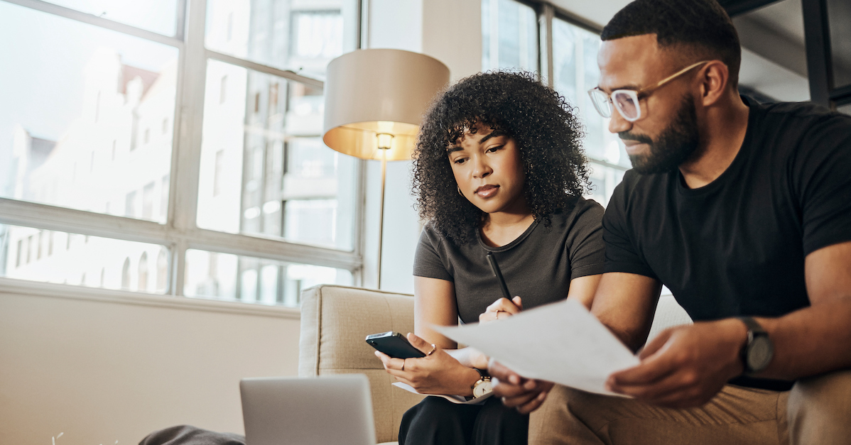 Couple on couch researching on computer finances