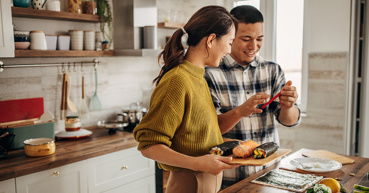 happy couple cooking together in kitchen