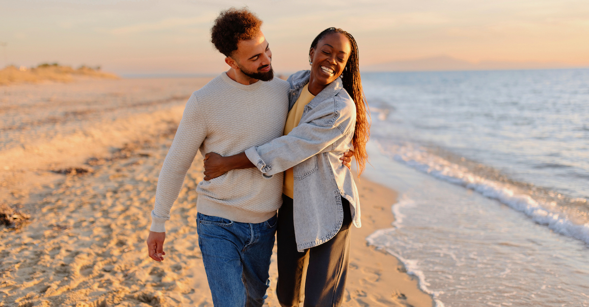 Cute happy couple walking on beach date