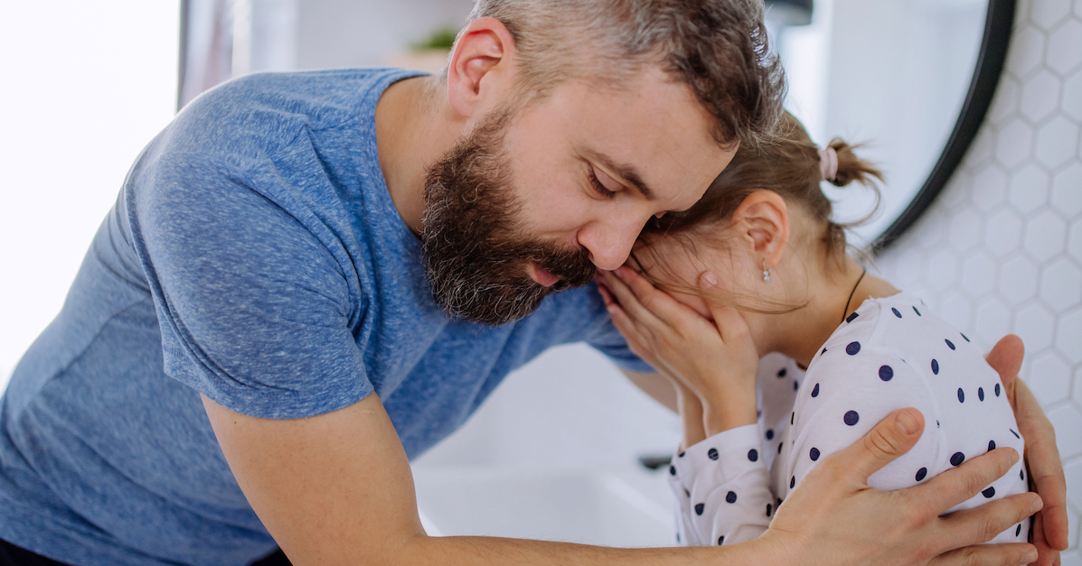 Dad comforting crying daughter