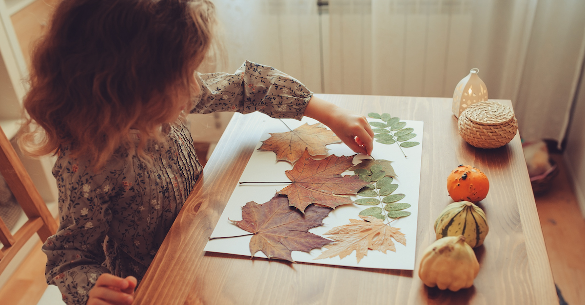 Little girl doing fall craft with leaves