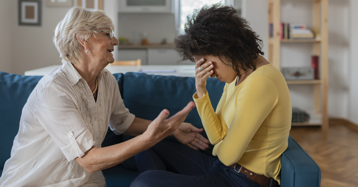 Women on couch arguing and upset setting boundaries conflict mother in law