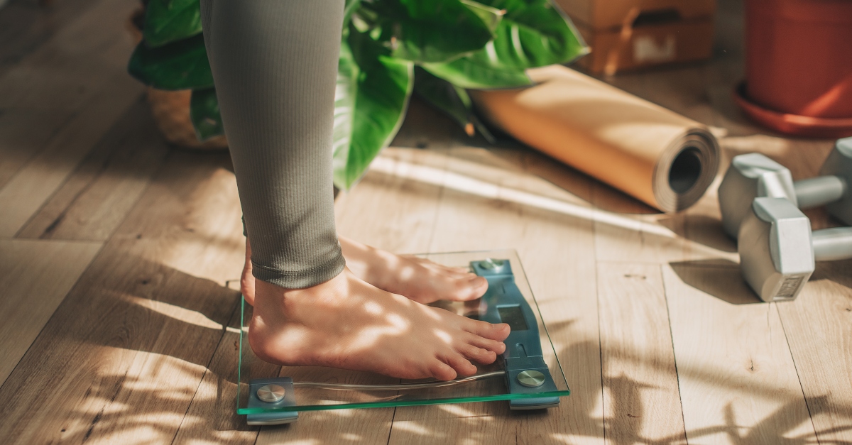 Woman standing on a scale, looking at her weight