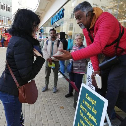 Street preacher Dia Moodley engages a young woman on the street in England