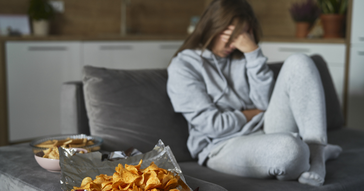 Teen girl upset on couch negative body image guilty for eating
