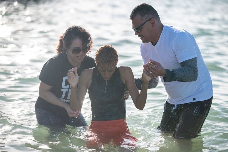 A girl is raised from the waters during a baptism on a Florida beach