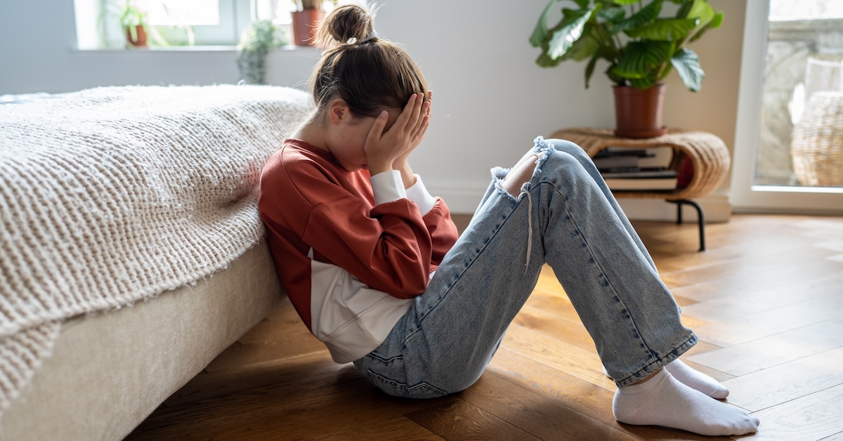 Teen girl crying in room anxious