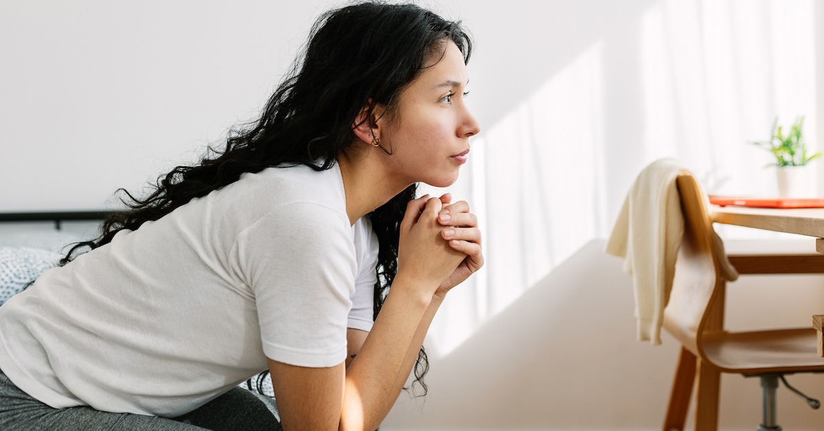 woman thinking praying on bed