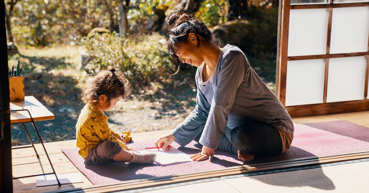 Mom and toddler daughter at home peaceful yoga mat coloring
