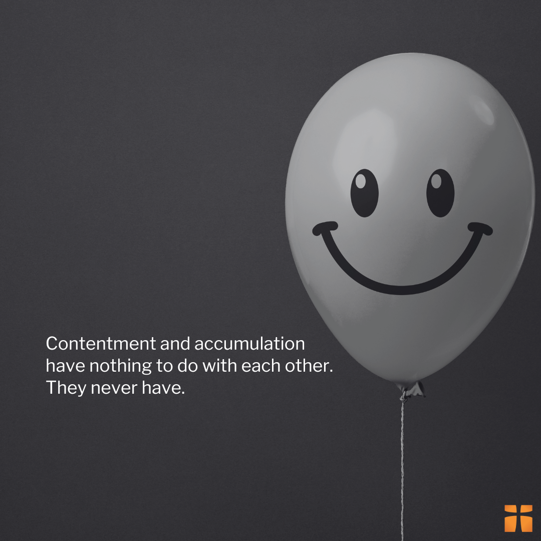 Minimalist quote graphic featuring a smiling balloon on a dark background with text about contentment not being tied to accumulation.