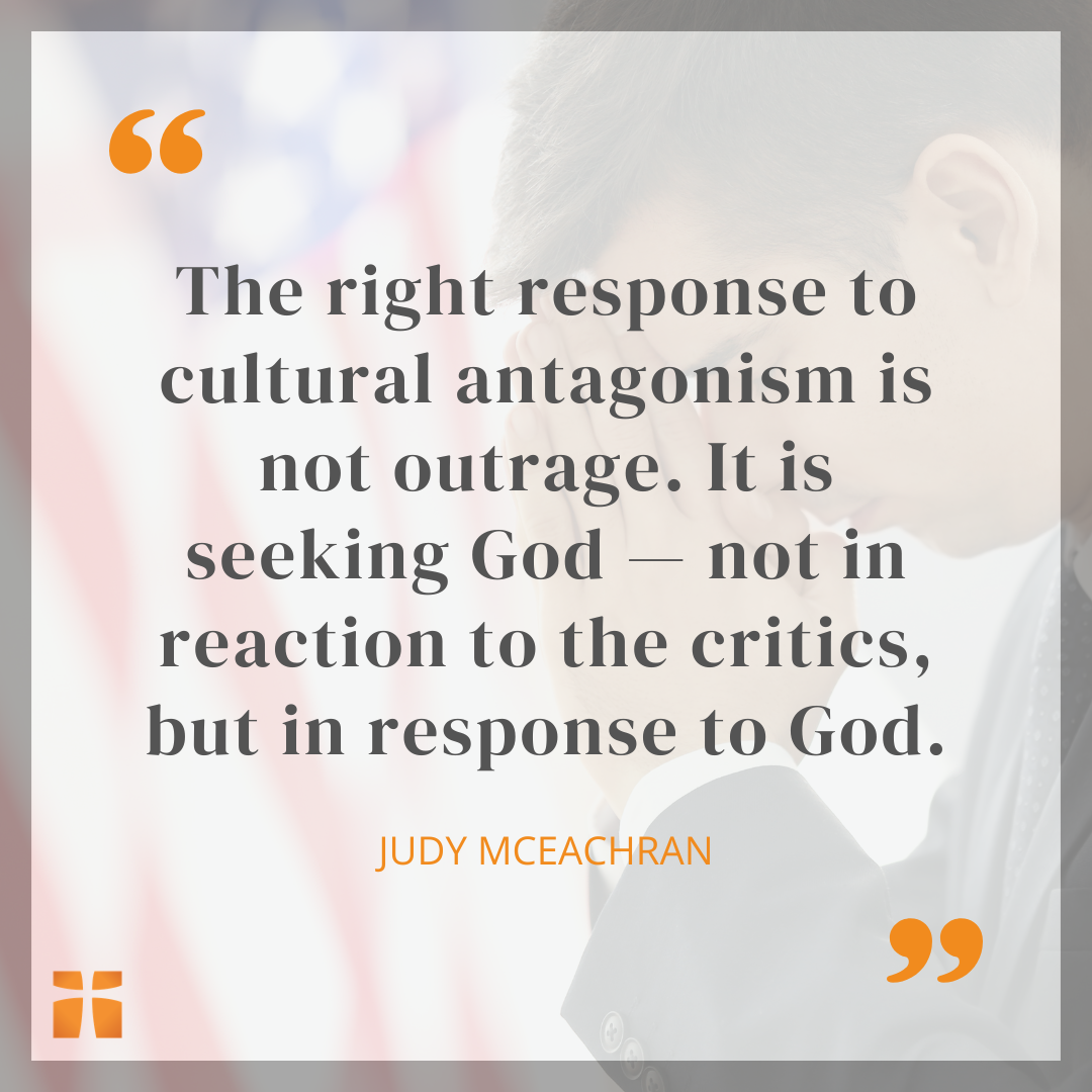 Person in prayer with hands clasped beside an American flag, overlaid with a quote from Judy McEachran about seeking God rather than responding with outrage to cultural opposition.